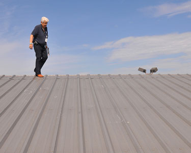 A commercial building inspector checking the roof of a large commercial property.